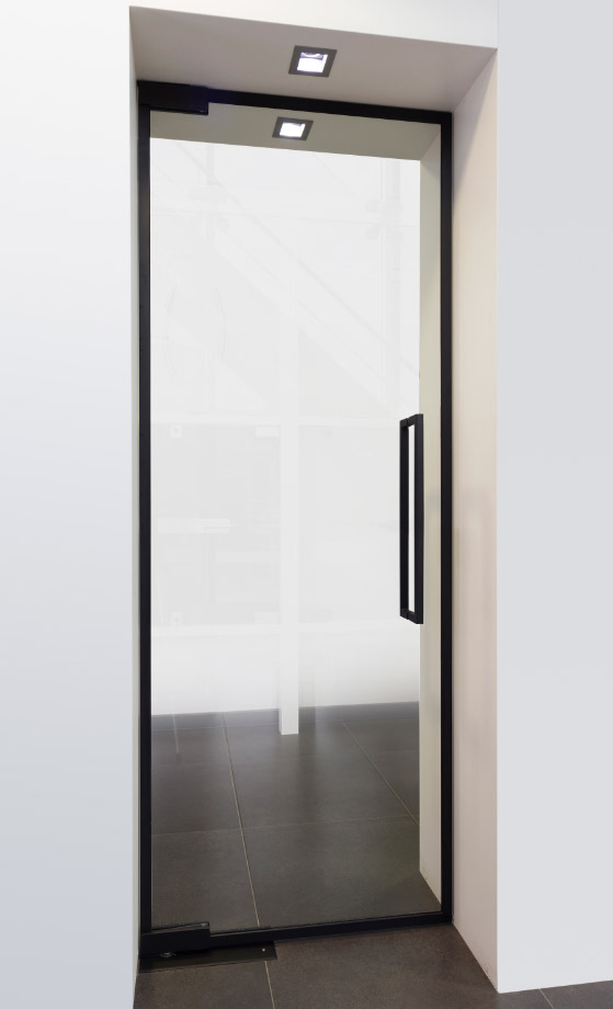Glazen binnendeur met veiligheidsglas en zwart kader in een woning met kinderen